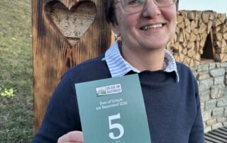 Himbeernest-Gastgeberin Andrea Schmidhofer mit der Bewertungs-Urkunde von Urlaub am Bauernhof 2026.